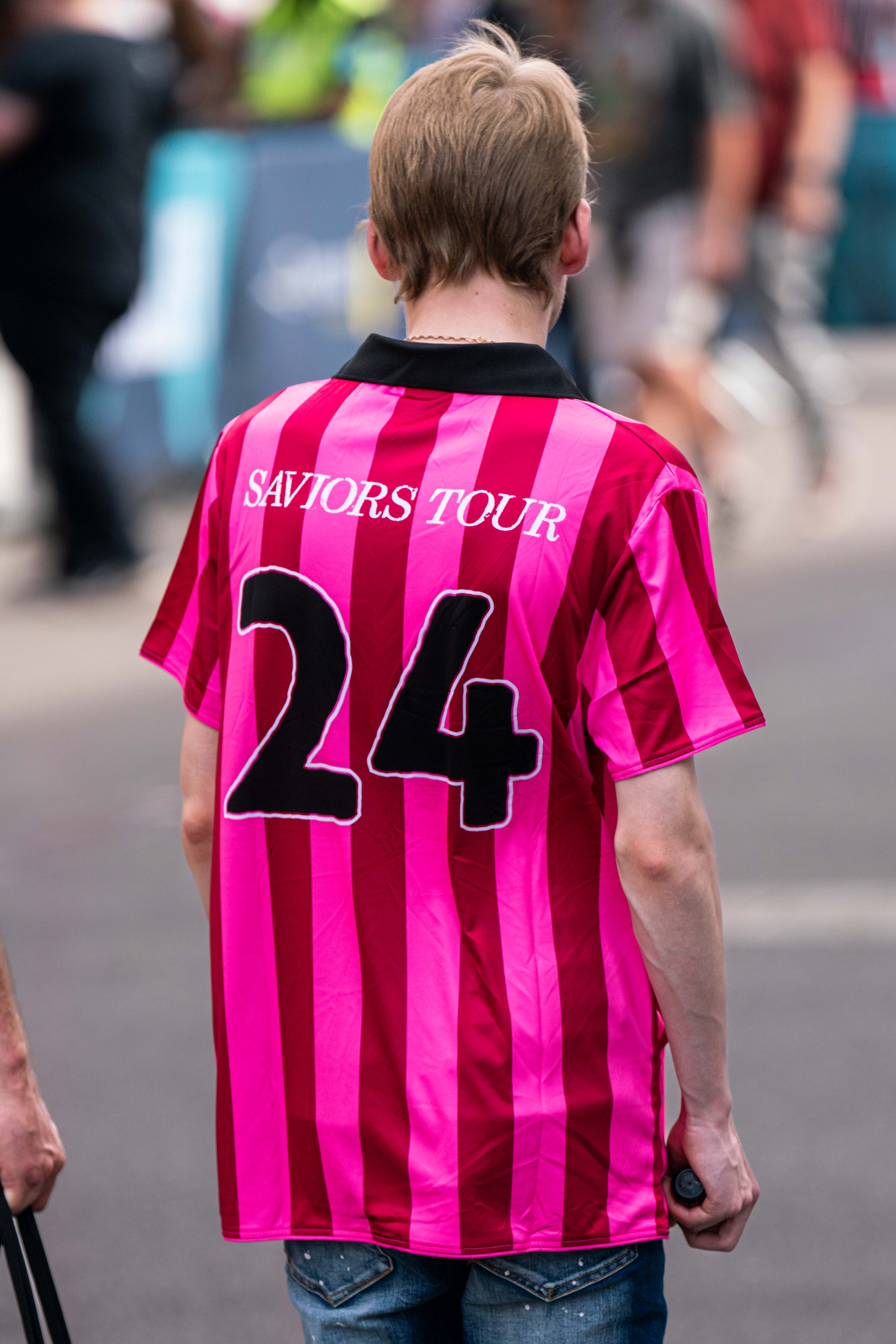 A Green Day fan wears a tour t-shirt as they walk towards the stadium