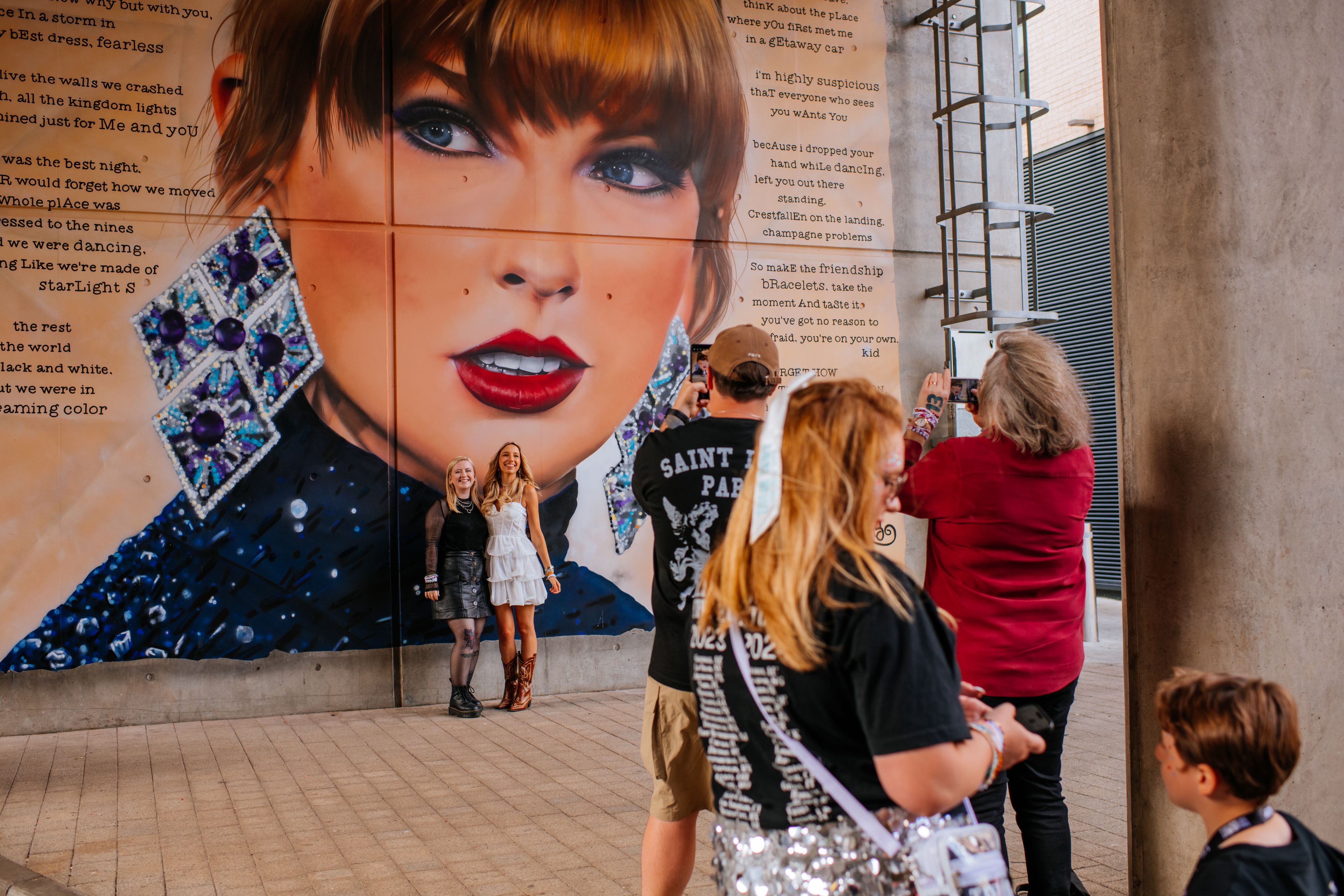 Taylor Swift fans pose in front of the mural painted outside Wembley