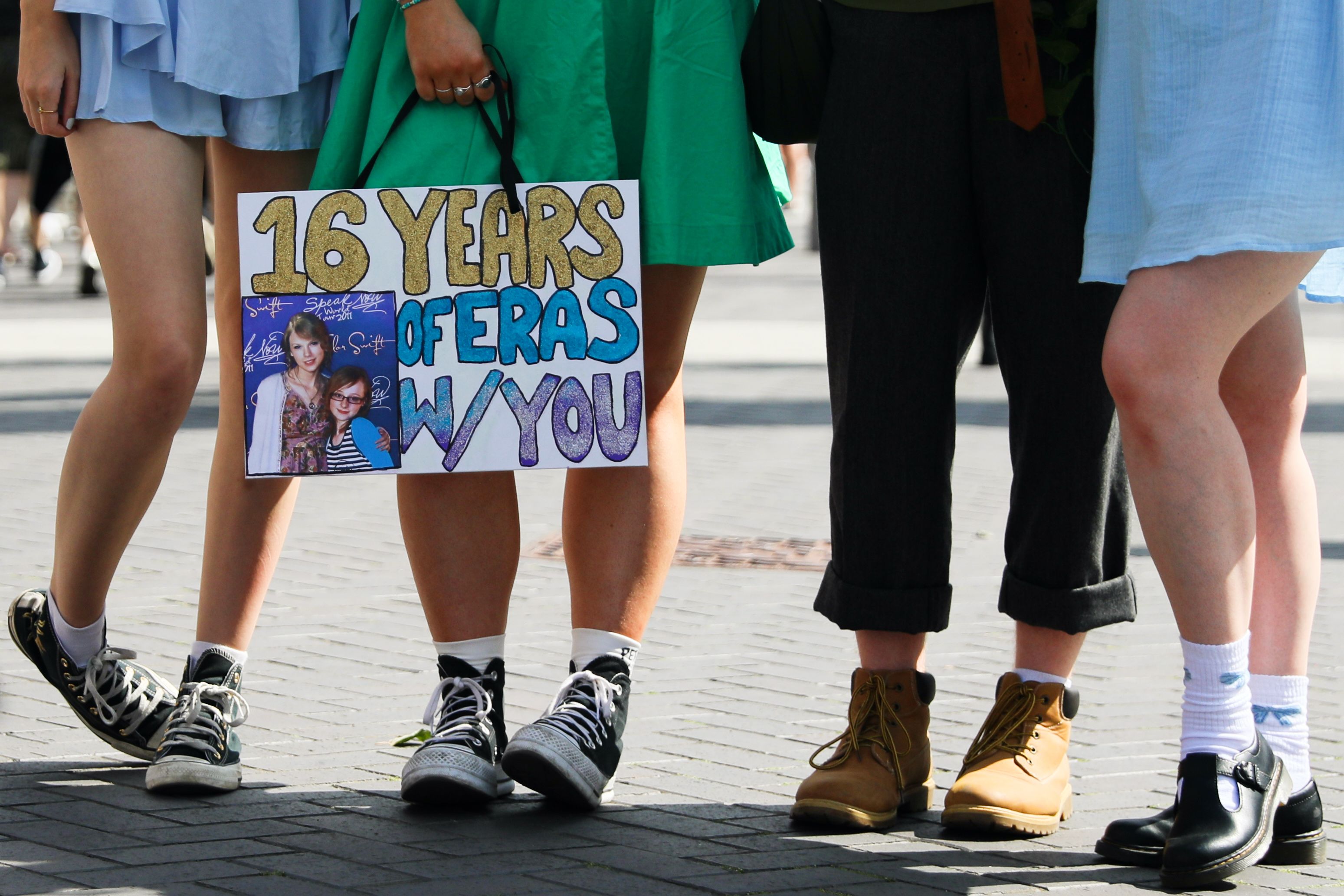Taylor Swift fans hold a homemade sign which reads '16 years of Eras with you'