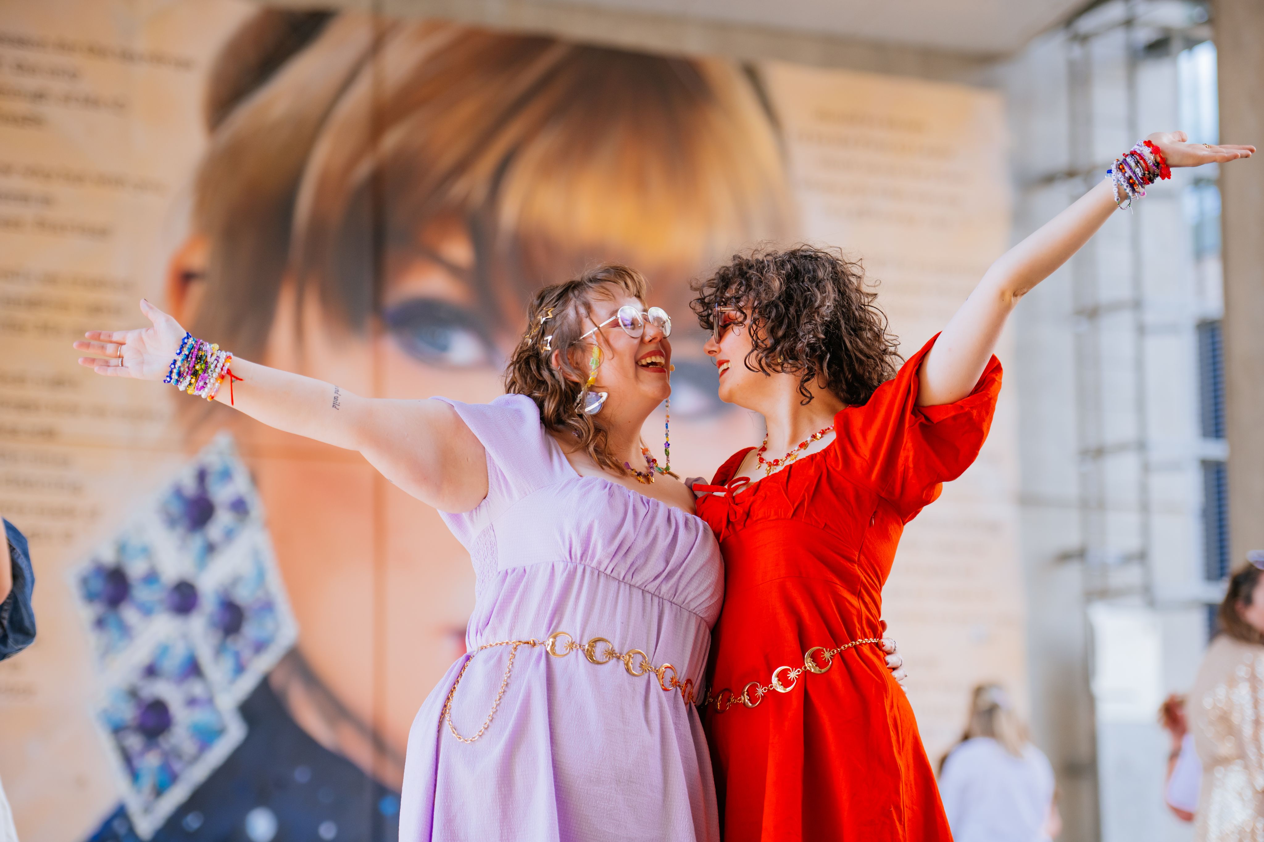 Two Taylor Swift fans pose in front of the mural outside Wembley Stadium