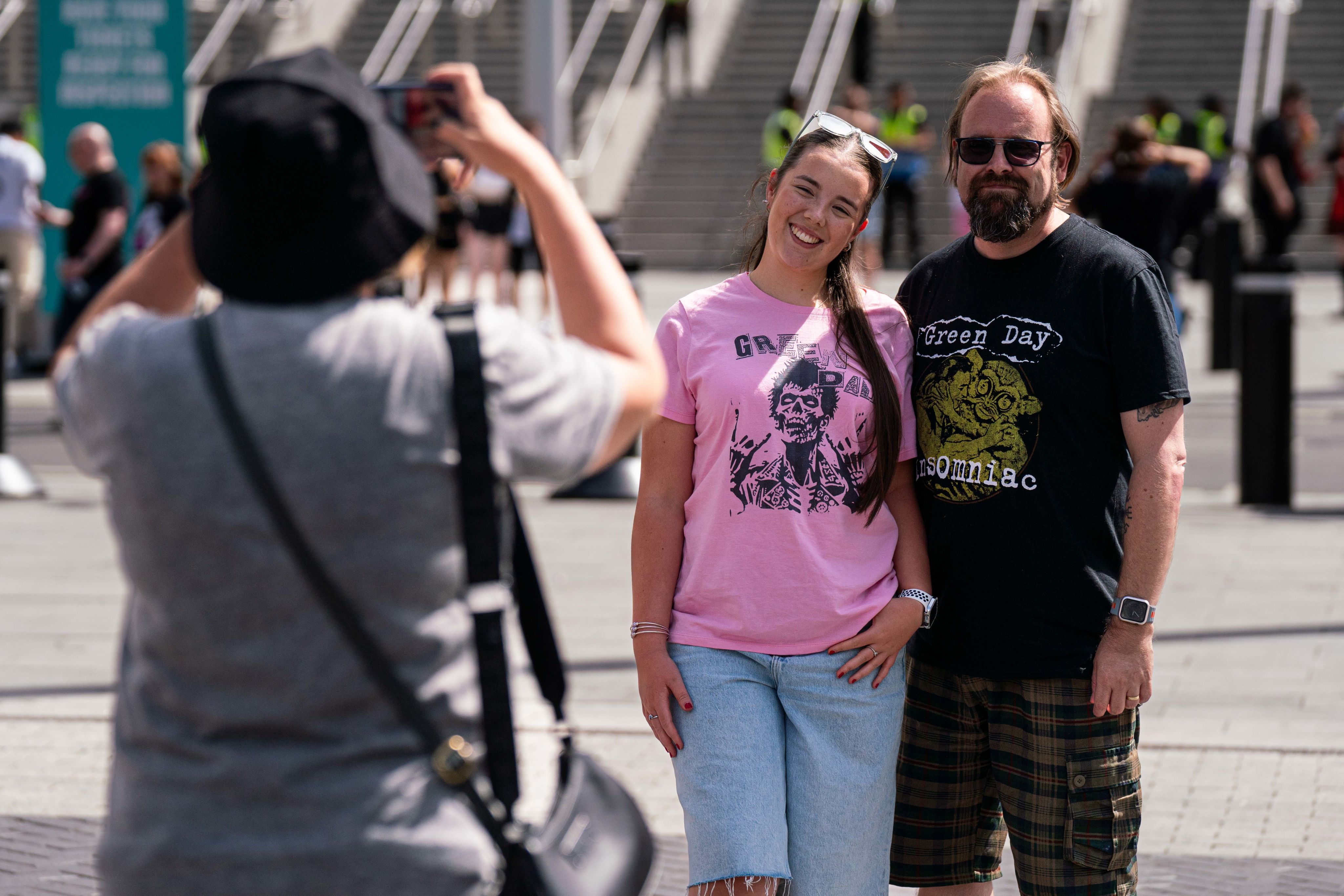 Two Green Day fans pose for a photo in front of the arch