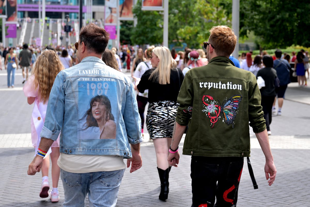 Taylor Swift fans walk towards the stadium in their personalised denim jackets