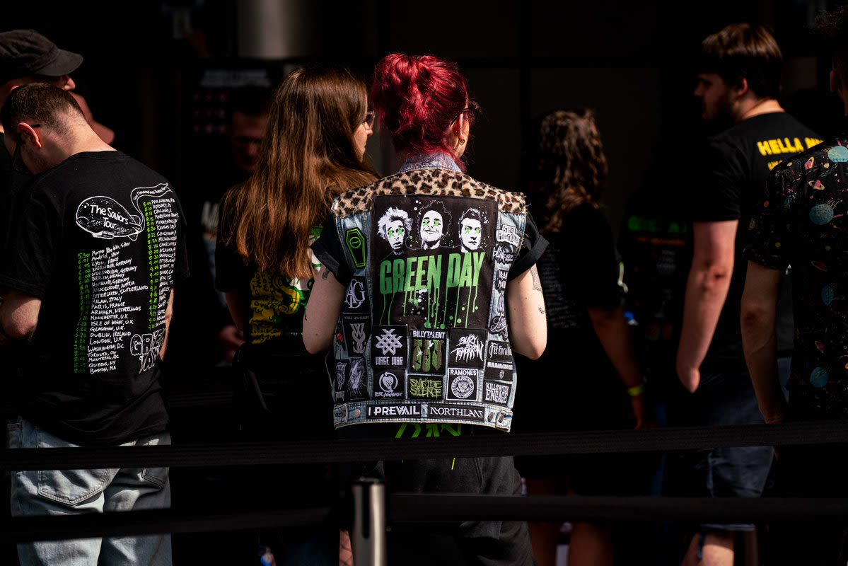 A photograph taken of a Green Day fan walking towards Wembley Stadium wearing a Green day sleeveless denim jacket