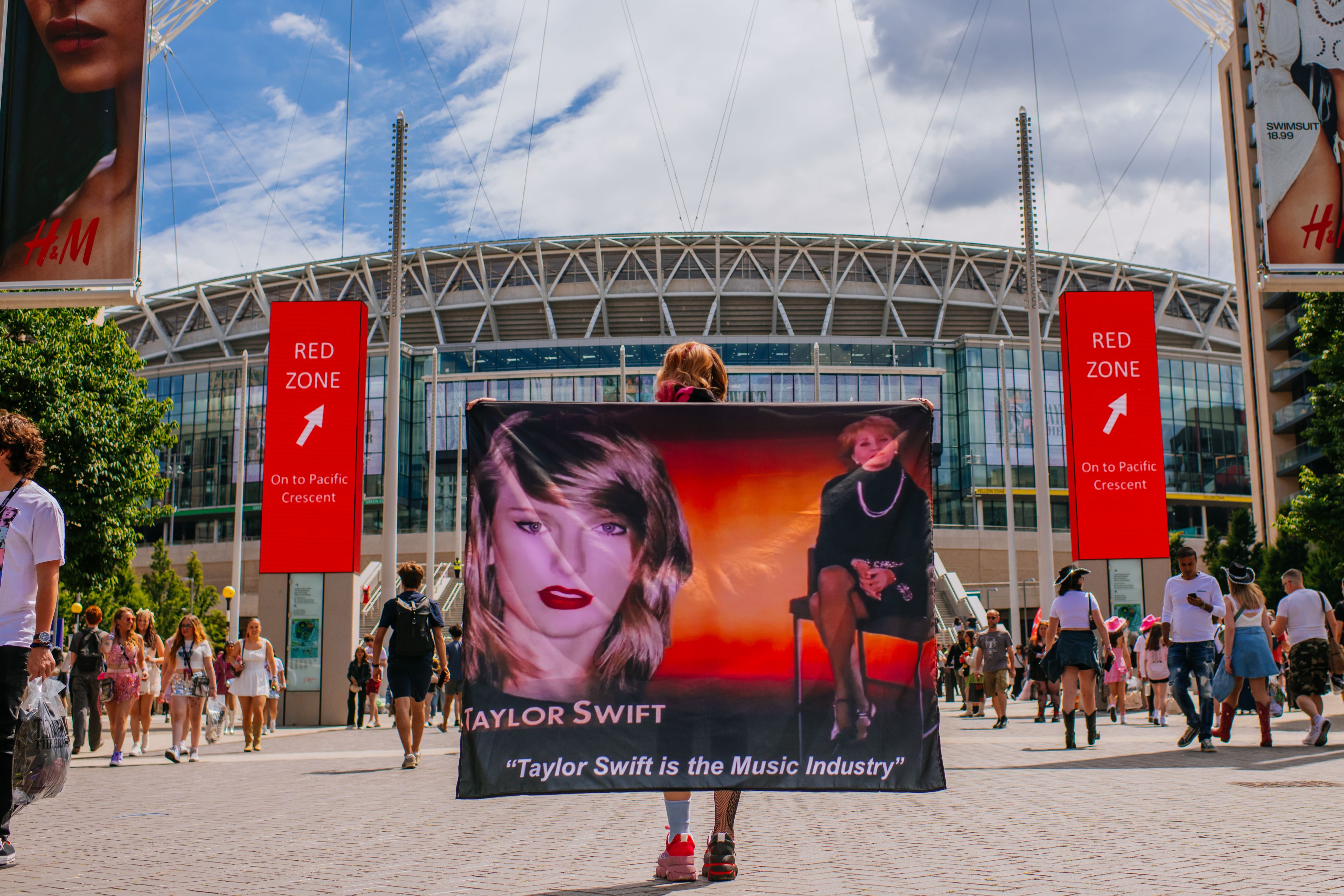 A taylor Swift fan poses with a flag outside Wembley