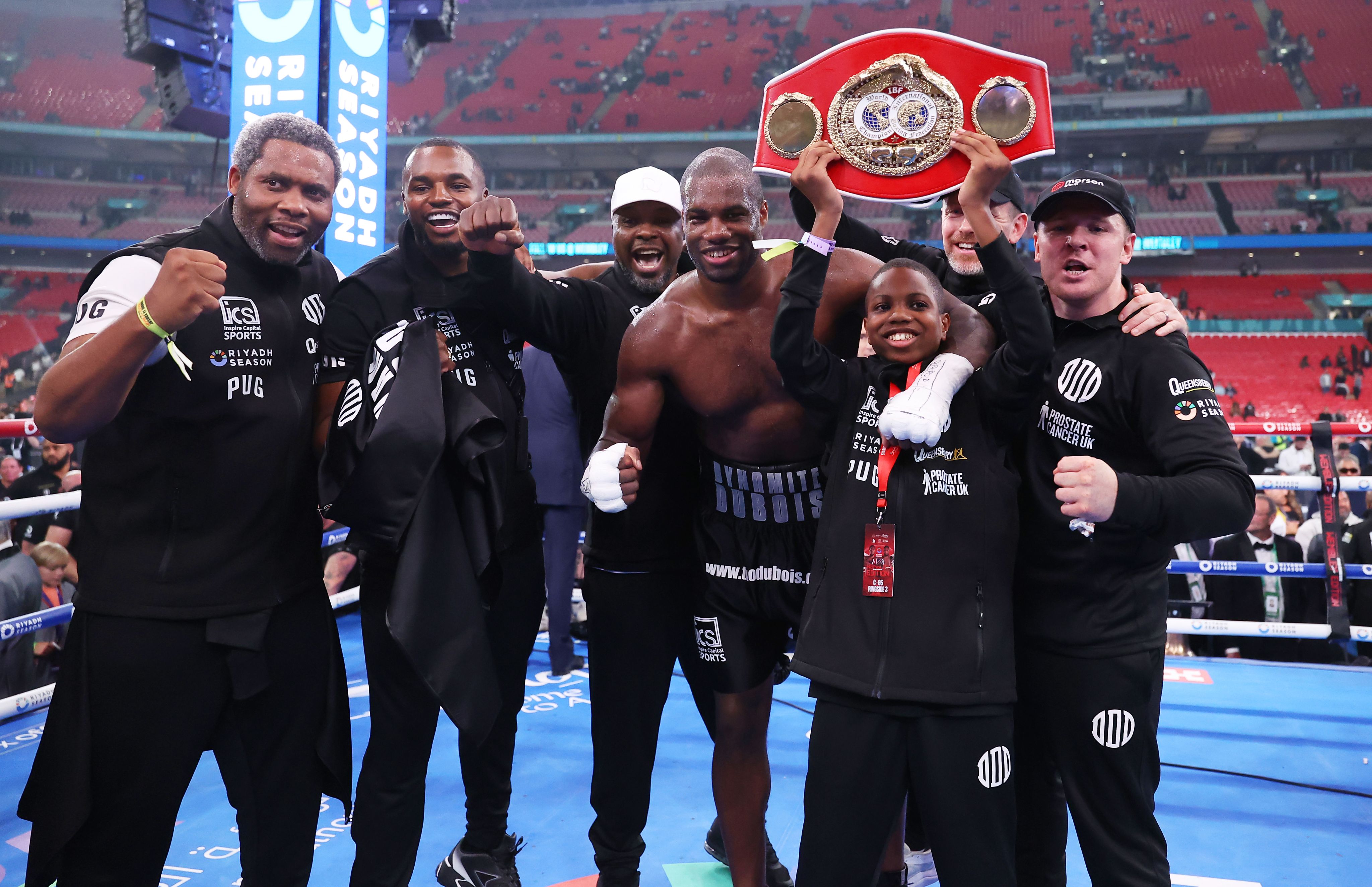 Dubois and his entourage celebrate with the belt inside the ring. 