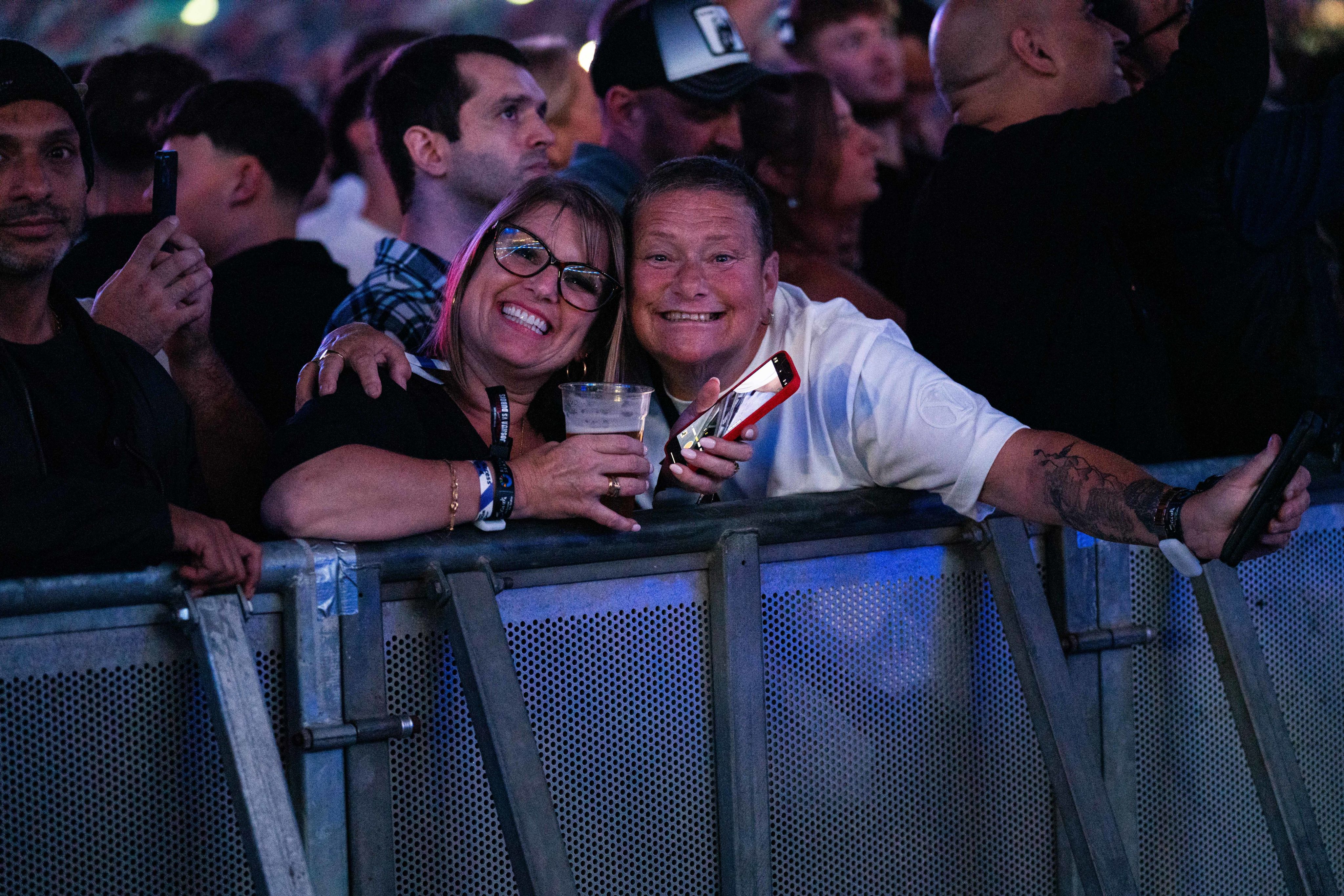 Two boxing fans pose together inside the stadium