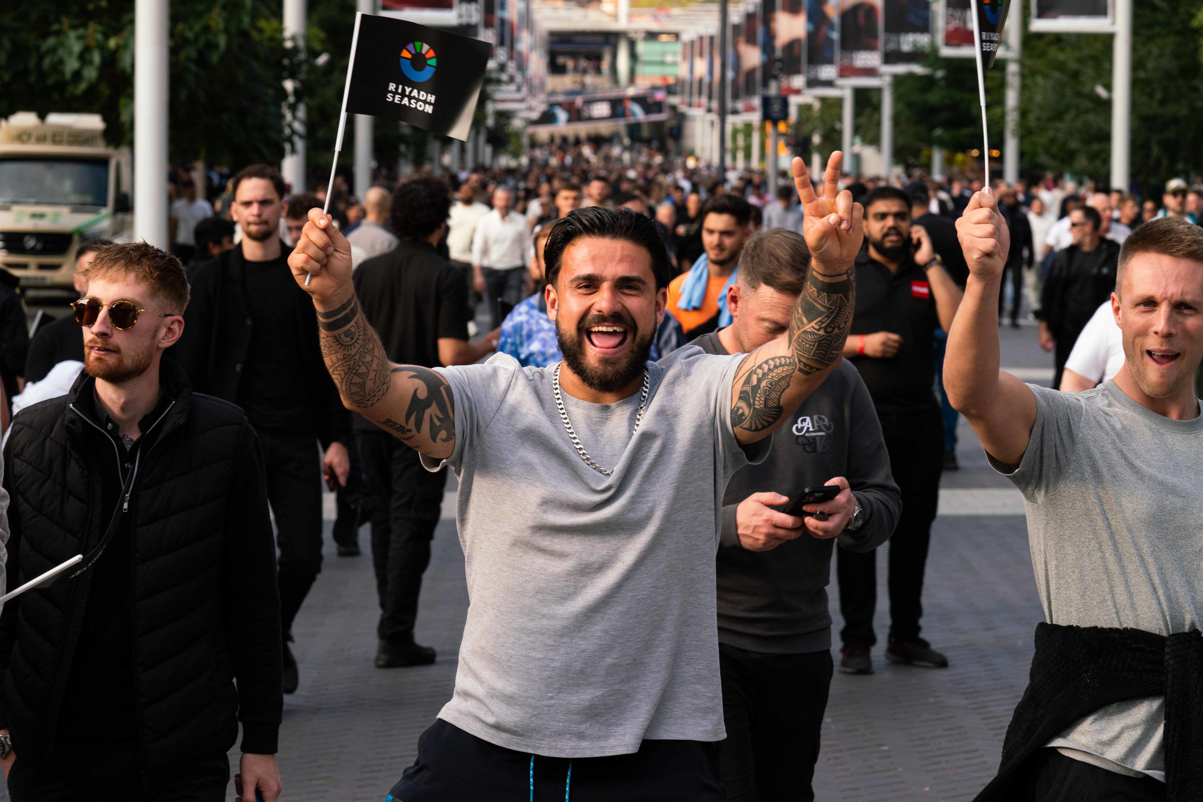 A supporter celebrates as they walk up Olympic Way prior to the boxing