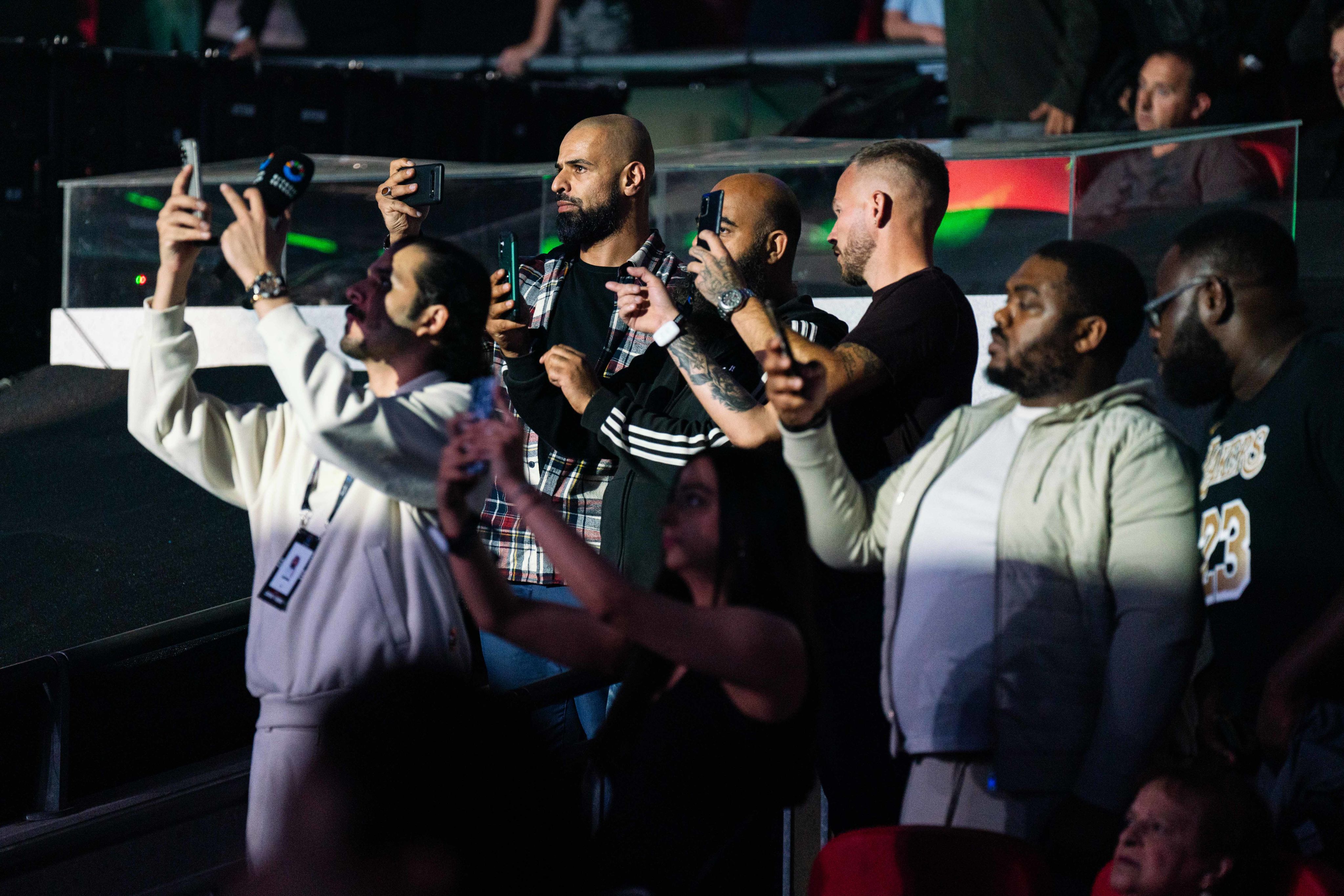 A group of boxing fans film on their phones during Joshua Dubois