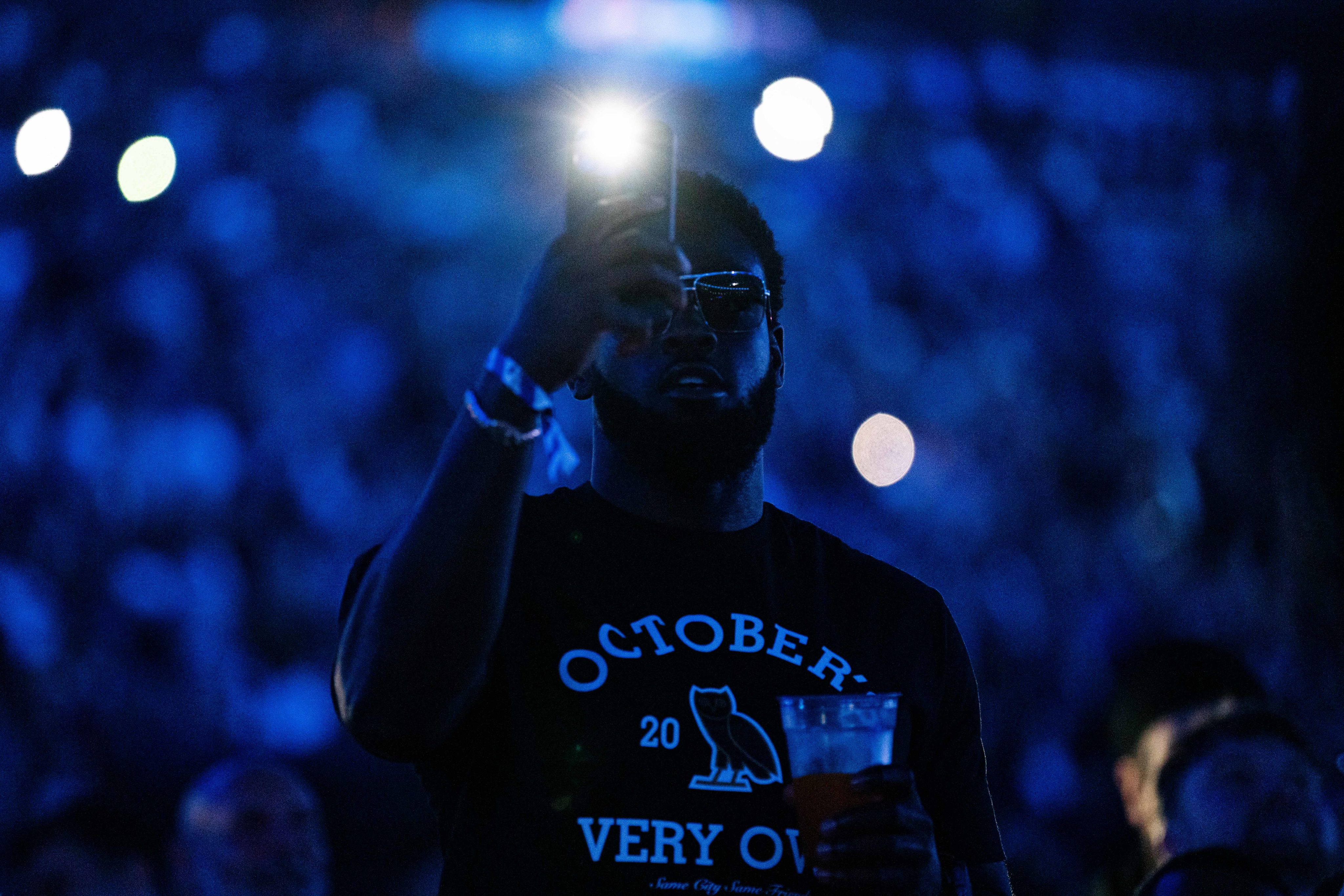 A boxing fan takes a photo with his phone during Joshua Dubois