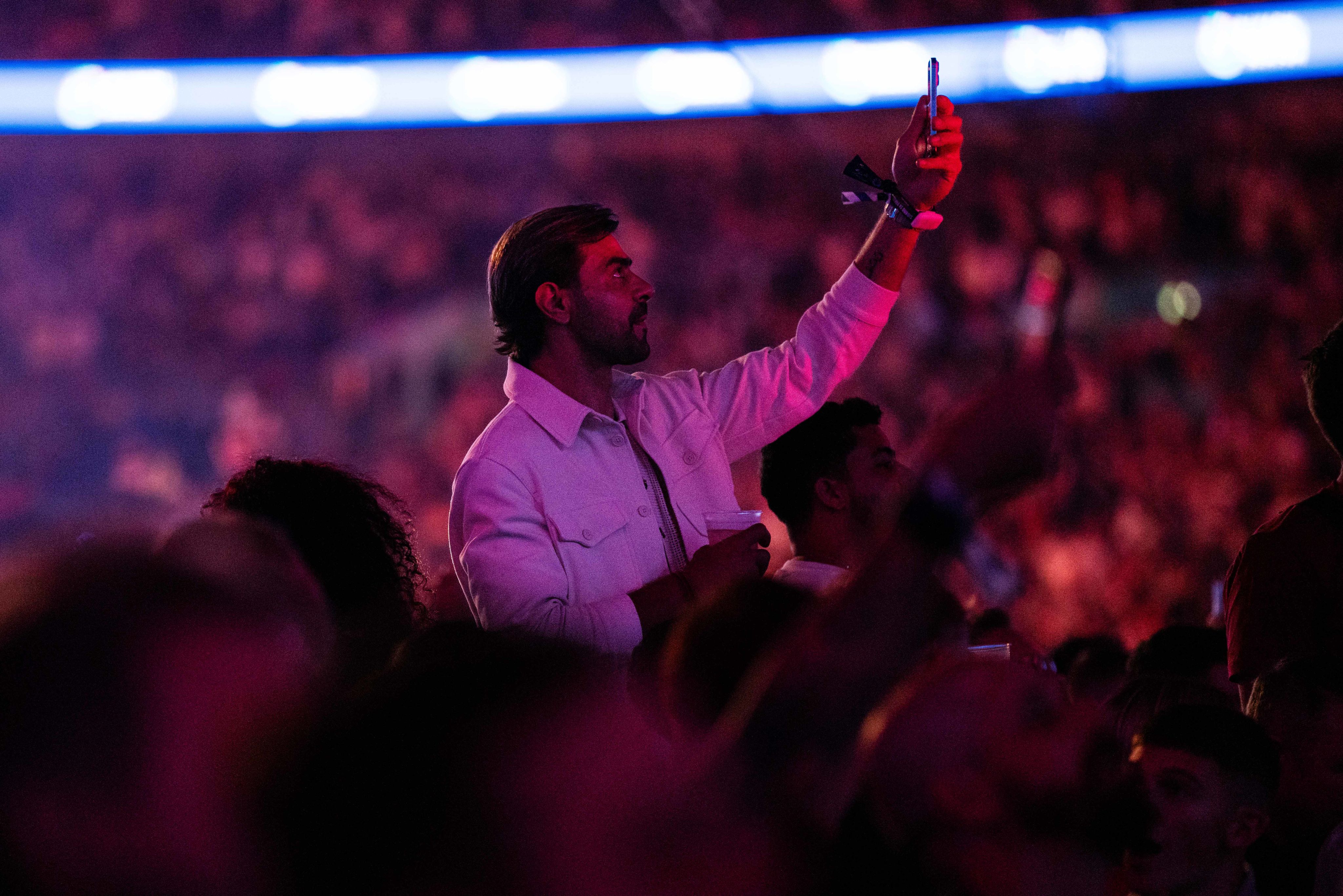 A boxing fan takes a picture on his phone during Joshua Dubois